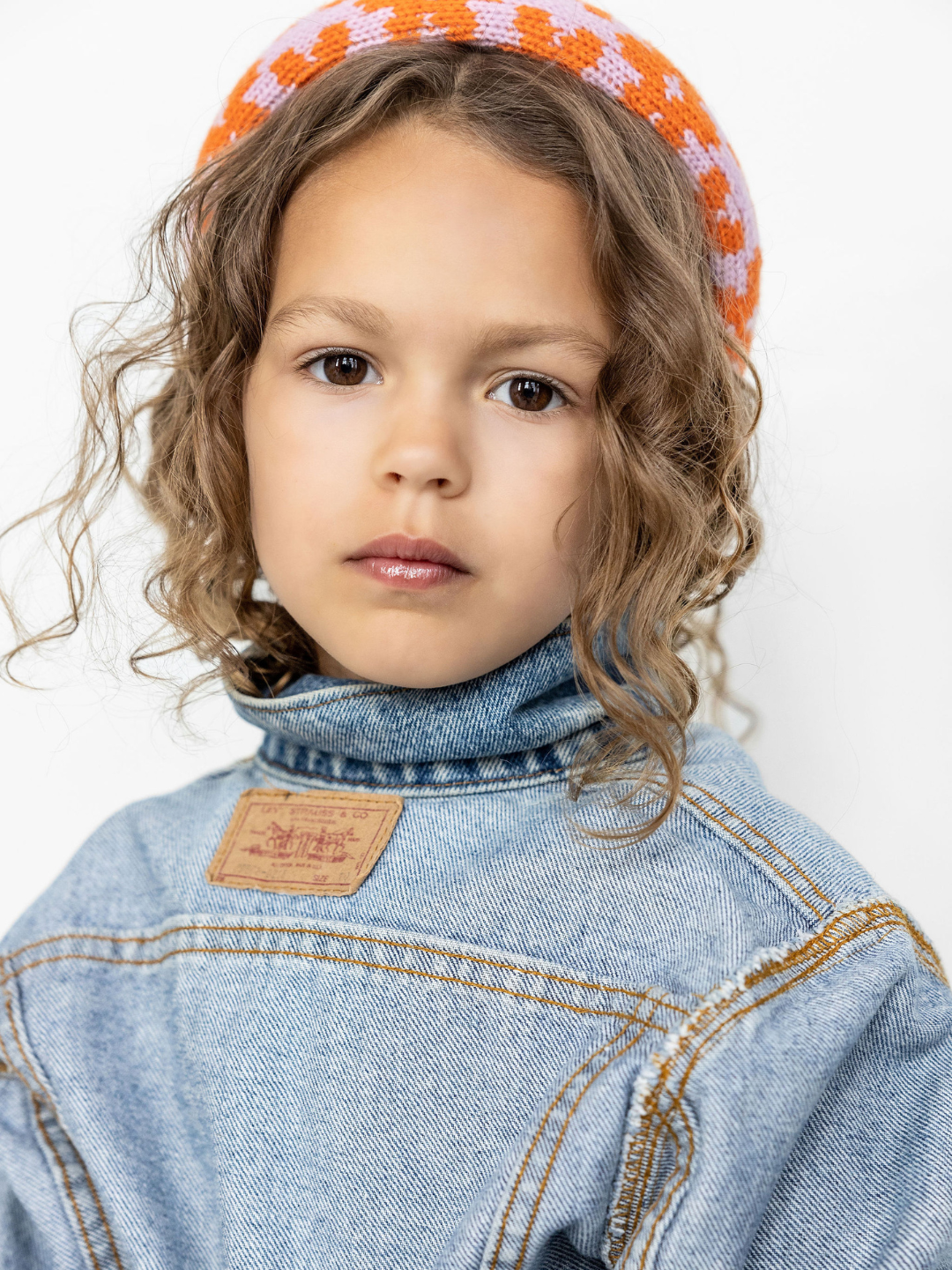A child is wearing the orange blossom headband