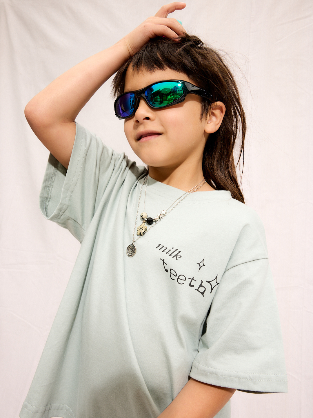 Mint | A child is wearing a mint Milk Teeth tee with reflective sunglasses and a necklace