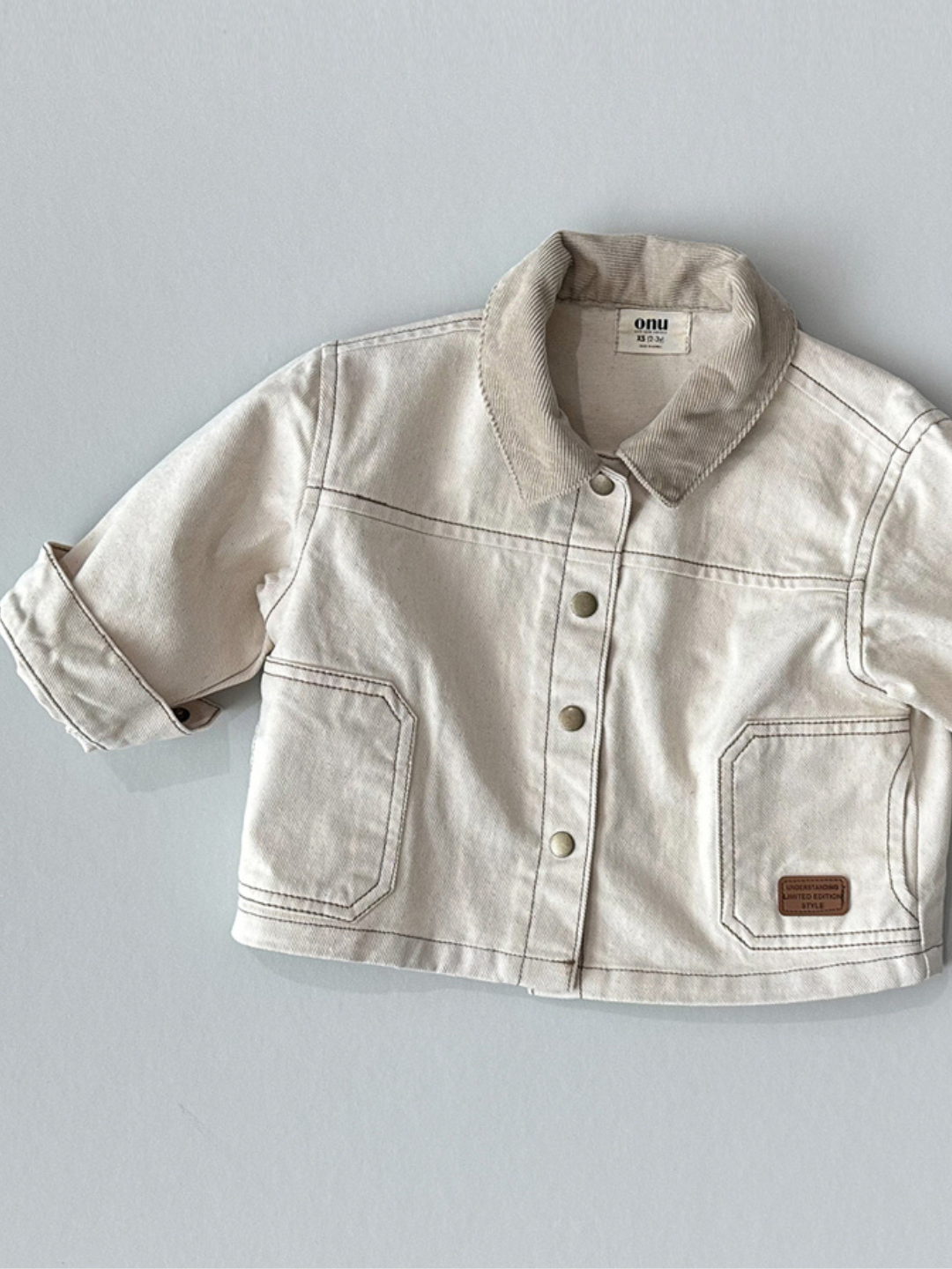 Natural | Front view of kids ecru denim jacket with beige corduroy collar.