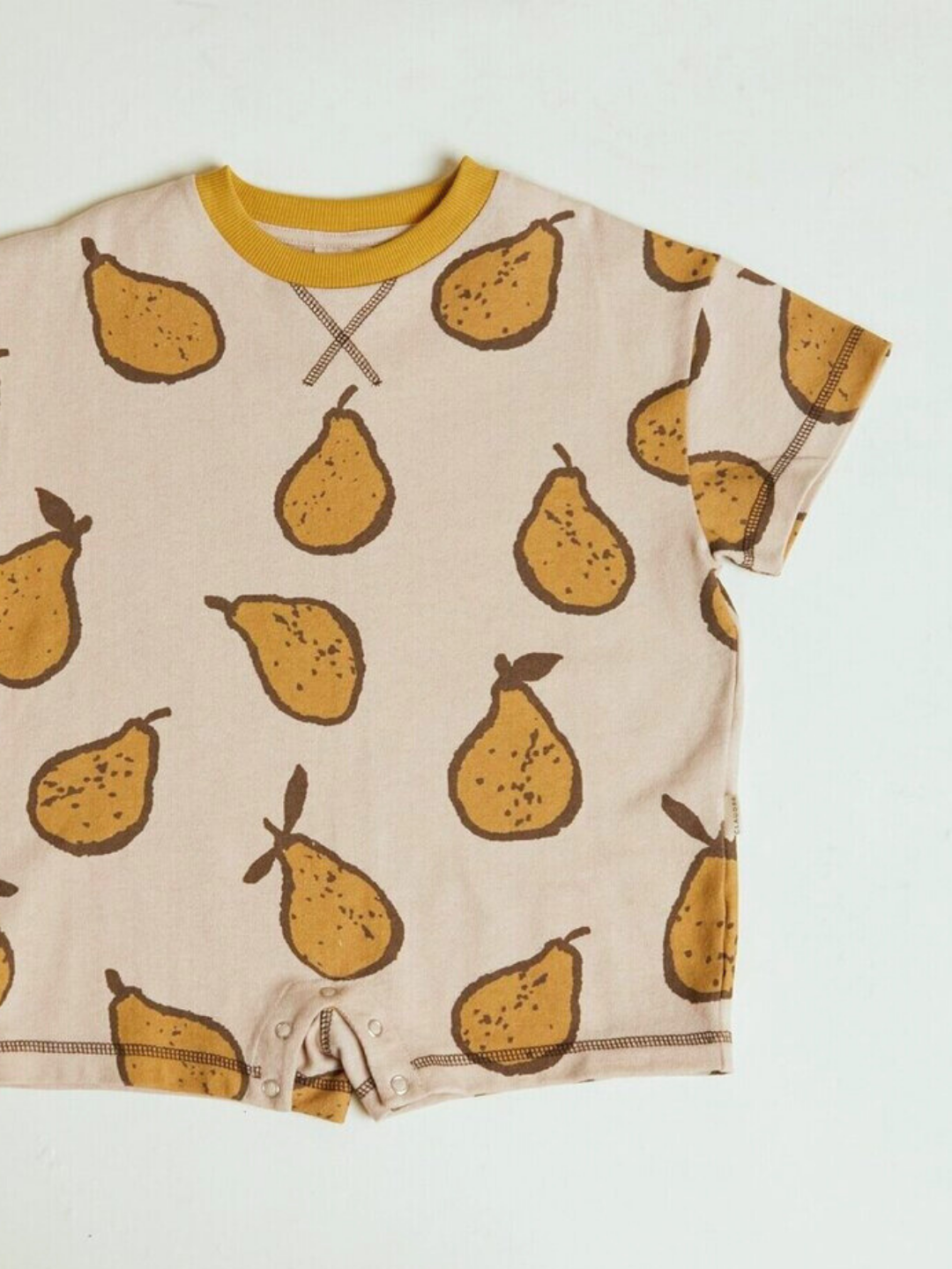The OPAL ALMOND PEAR ROMPER is a short-sleeve beige baby romper featuring a yellow pear print, brown stitching, and snap buttons at the crotch.
