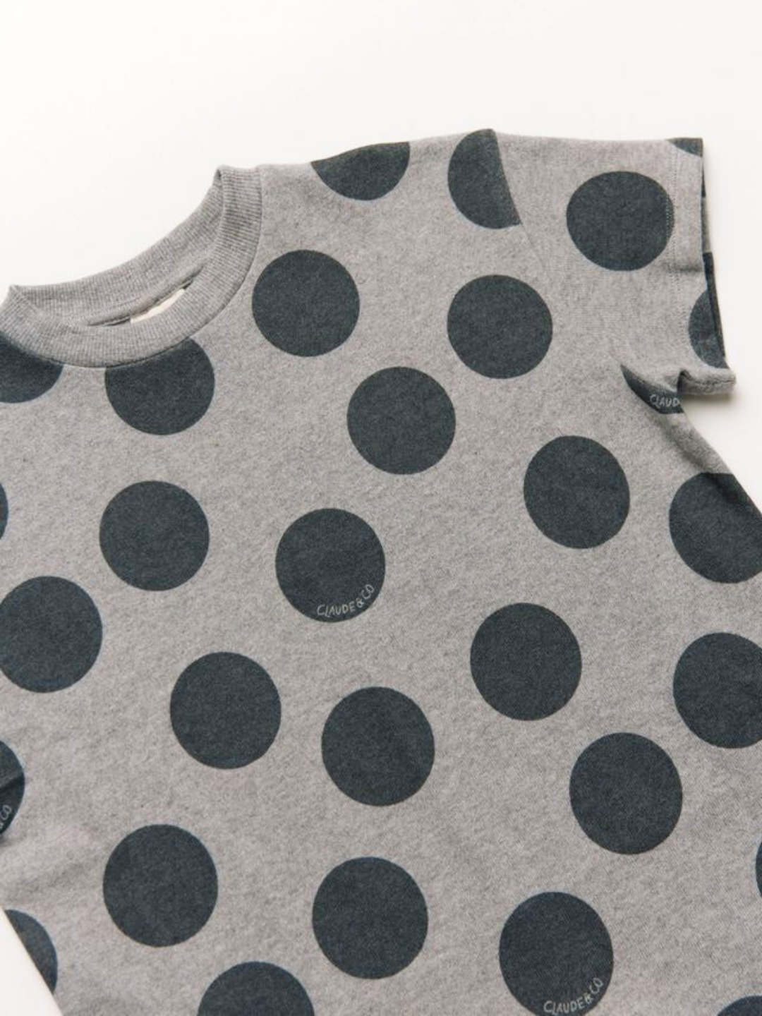 The OPAL MARL SPOT ROMPER features a gray design with large, evenly spaced black polka dots.