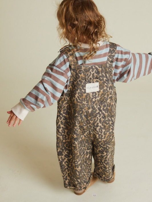 Second image of The BLYTHE LEOPARD DUNGAREE features brown leopard print, adjustable shoulder straps, and front metal buckles, displayed flat on a white background. Shipping costs may apply.