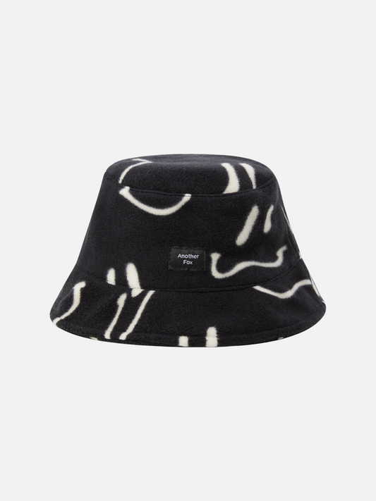 Image of A front view of the black fleece bucket hat with white wavy smiley faces all over.