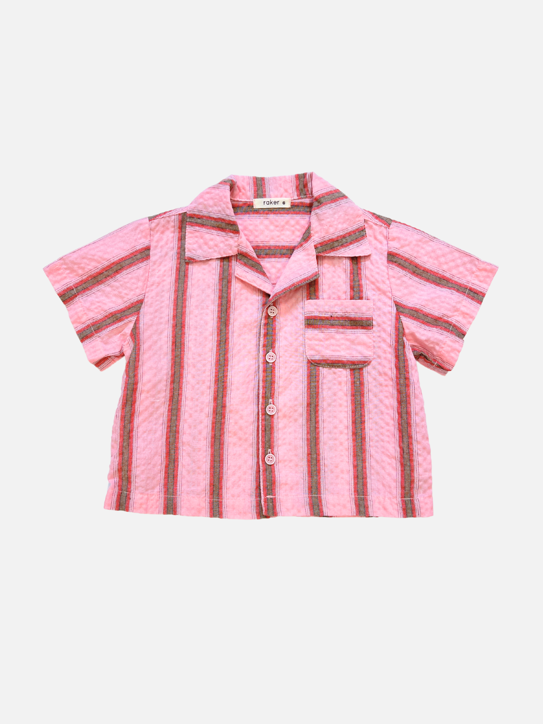 The HAVANA STRIPE SHIRT is a vintage-inspired, short-sleeved pink cotton shirt with vertical red, black, and white stripes and a single chest pocket, shown laid flat against a white background.