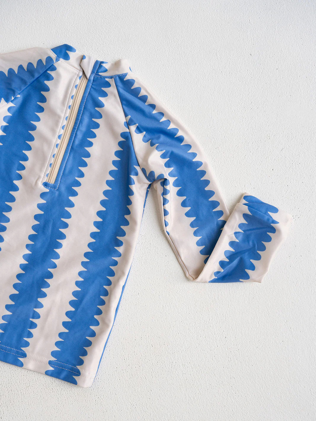Blueberry | Rashguard laid flat on surface showcasing the back zipper