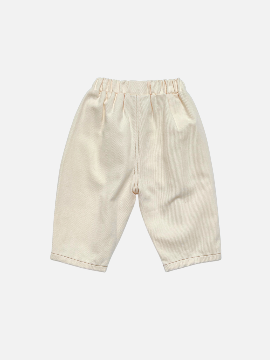 Ecru | Back view of a pair of cream-colored toddler jeans with an elastic waistband, photographed flat against a light gray background.