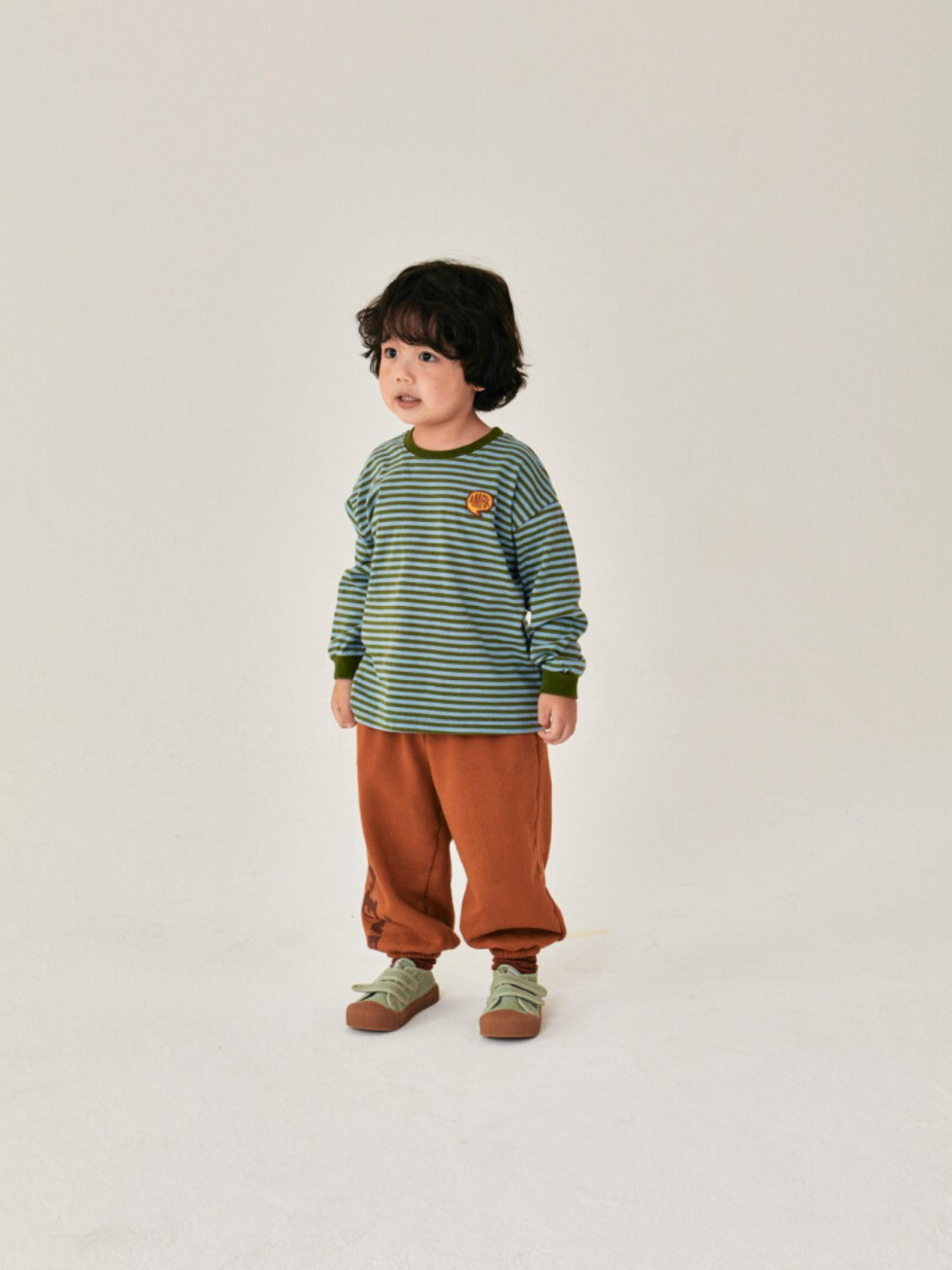 Sky/Olive | Child is wearing Comma Striped Longsleeve in Sky/Olive with orange baggy pants