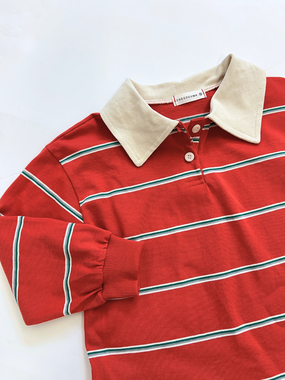The RETRO RUGBY LONGSLEEVE is a red tee with white and green stripes, classic rugby collar, and Korean kids’ brand inspiration, shown on a white background.