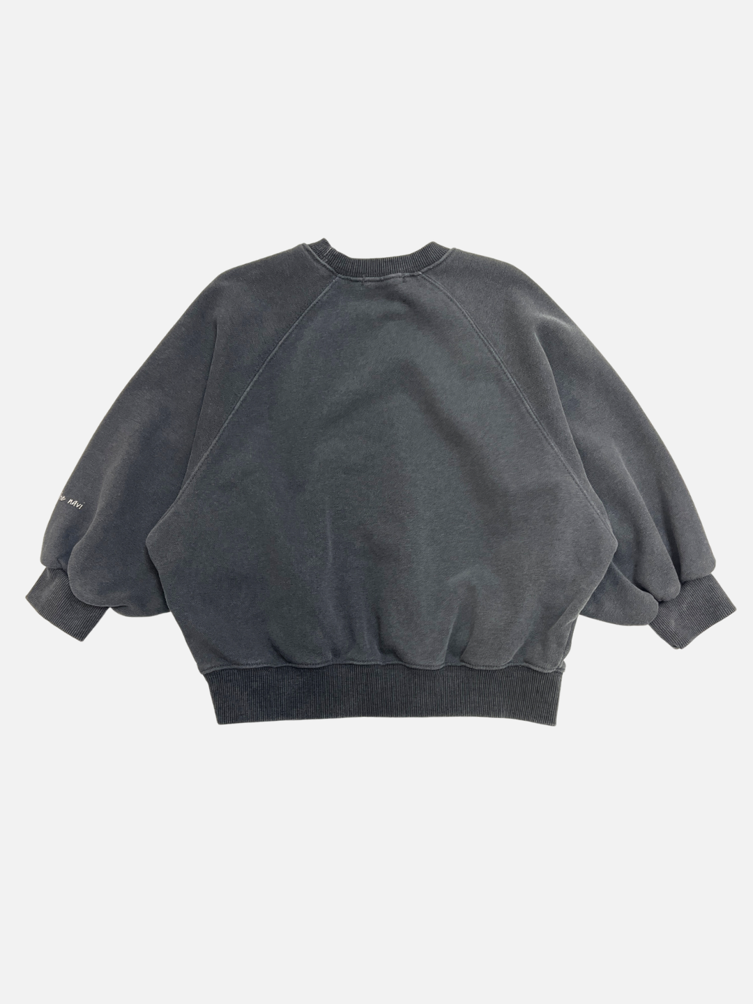 Charcoal | The PLAYTIME SWEATSHIRT is a dark gray, garment-dyed cotton kids’ sweatshirt with an oversized fit, balloon sleeves, and ribbed details. Shown laid flat on a white background to display the stylish back view—Korean-inspired design.