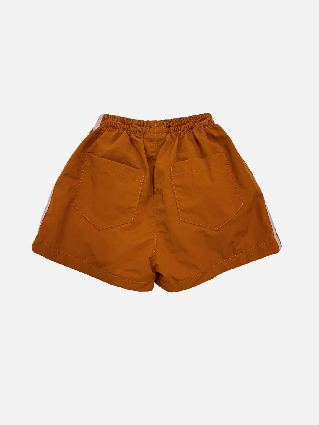 Rust | The SPRINTER SHORTS are orange track shorts with an elastic waist, two back pockets, and white side stripes, made from performance fabric and shown on a plain white background.