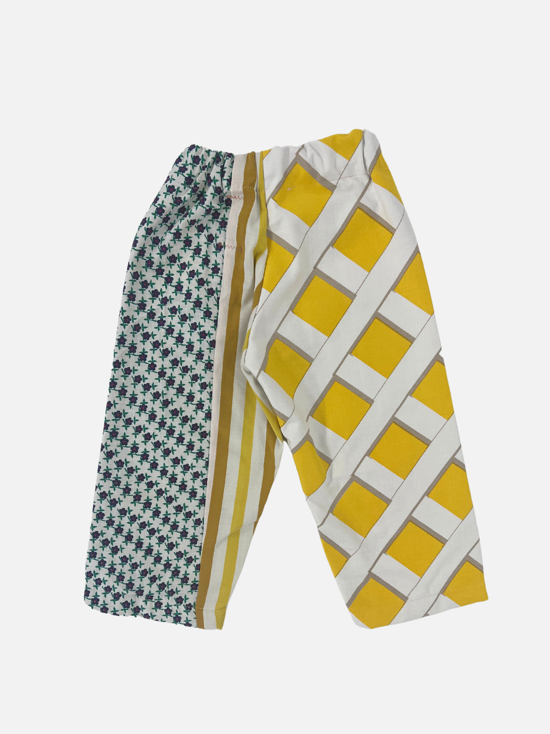 Back view of kid's patchwork pant. Left leg - fence resembling yellow print. Right Leg - little flowers & stripes.