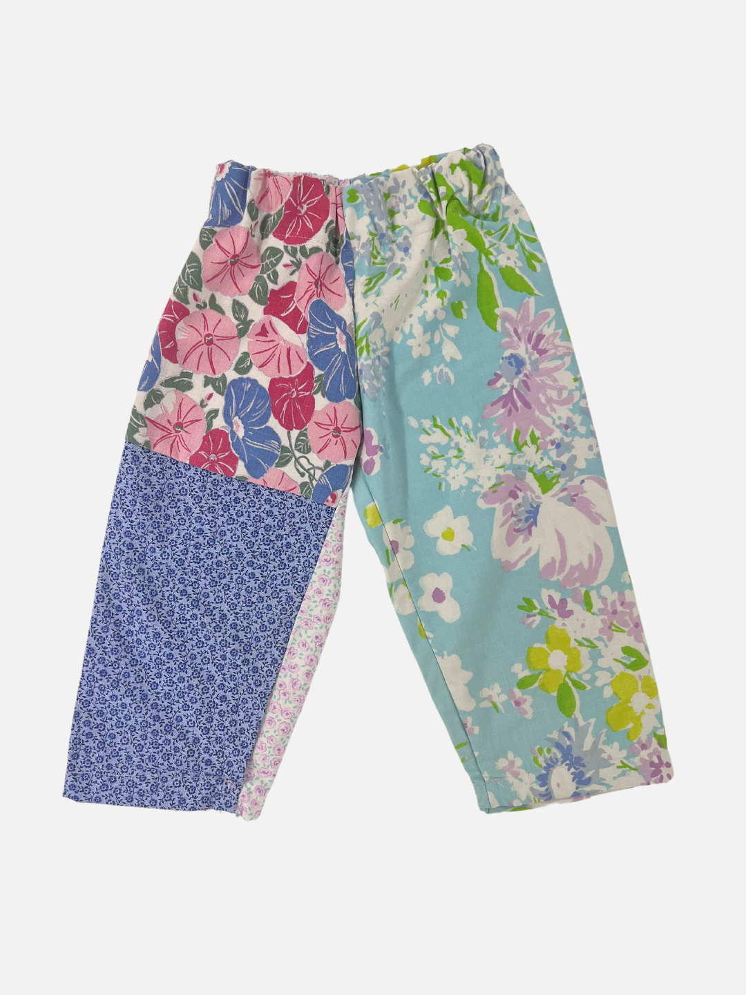 Front view of kid's patchwork pant. Left leg - small flowers on blue, big pink and blue flowers. Right Leg - Flowers on light blue background.