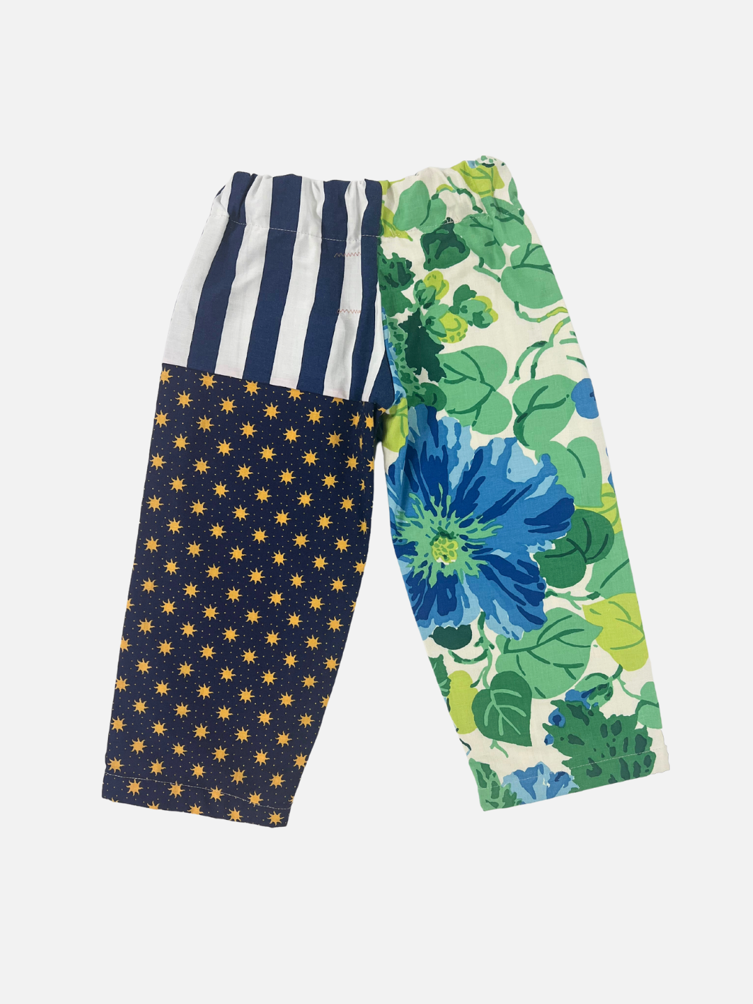 Back view of kid's patchwork pant. Left leg - big blue flowers. Right leg - stripes & all over suns print.
