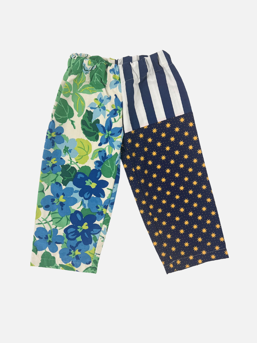 Front view of kid's patchwork pant. Left leg - big blue flowers. Right leg - stripes & all over suns print.