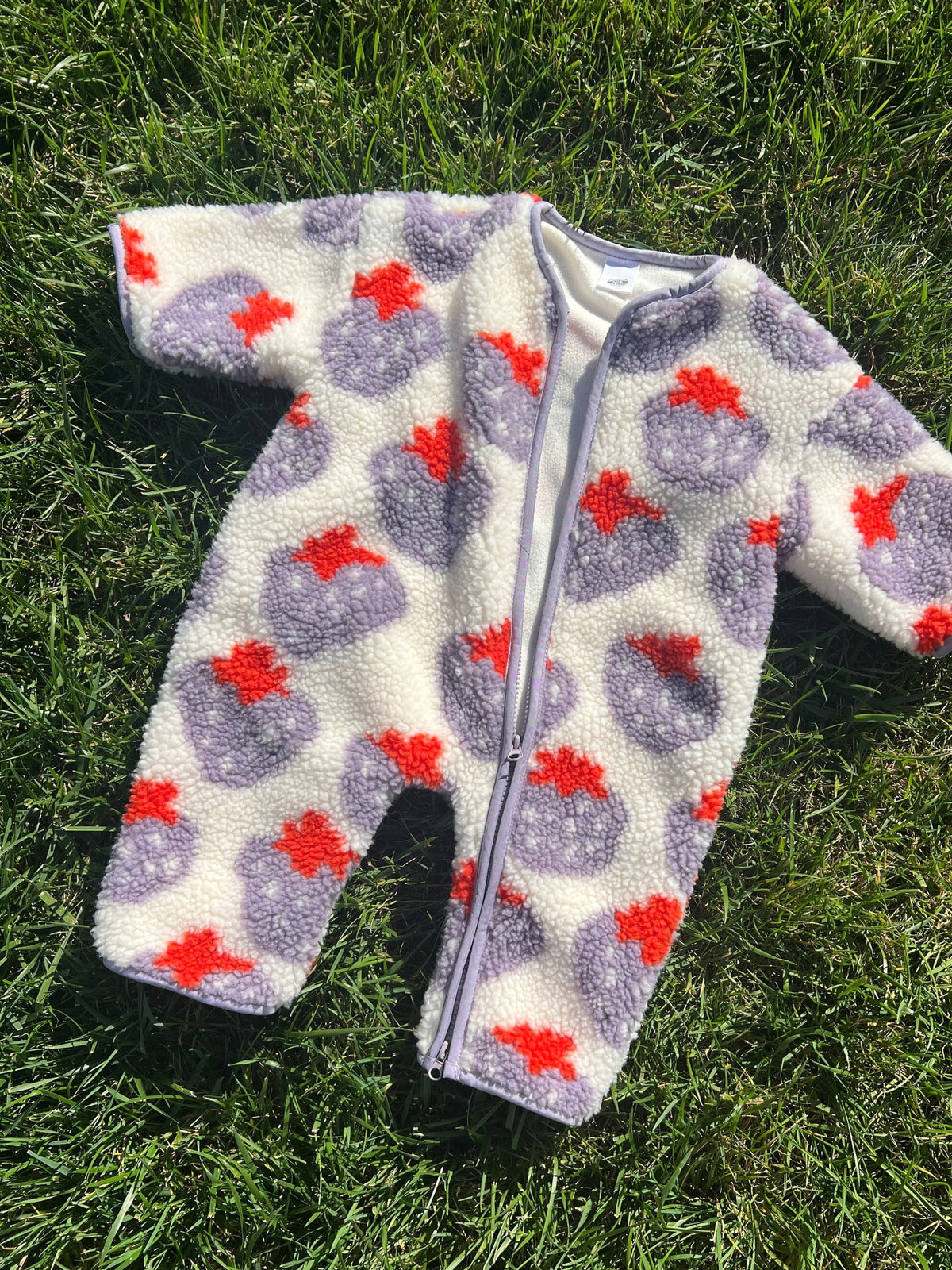 STRAWBERRY SHERPA FLEECE STROLLER SUIT in white sherpa fleece with a purple and red strawberry pattern, featuring a front zipper and cozy winter layer for babies.