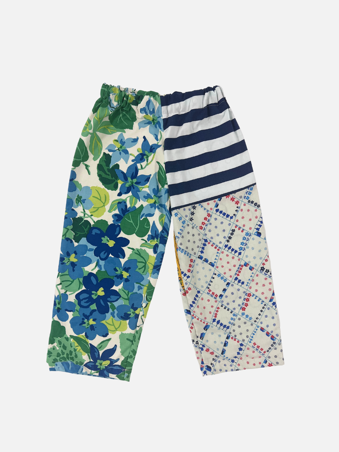 Front view of kid's patchwork pant. Left leg - big floral print. Right Leg - stripes & little town print.