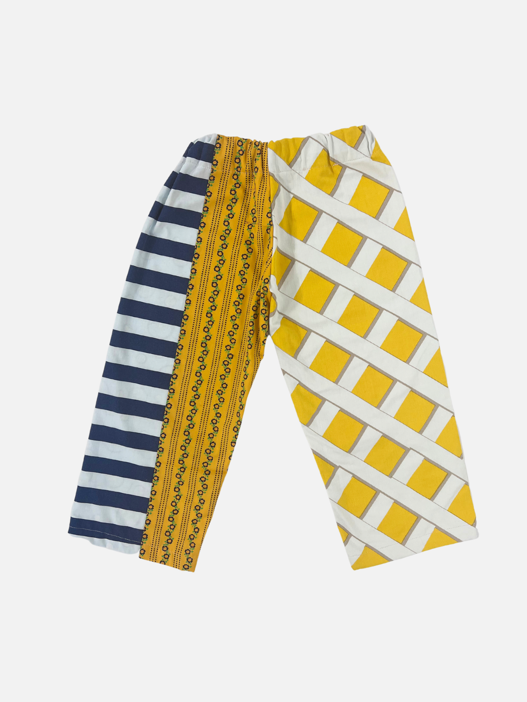 Back view of kid's patchwork pant. Left leg - fence resembling yellow print. Right Leg - navy stripe & mini flowers.