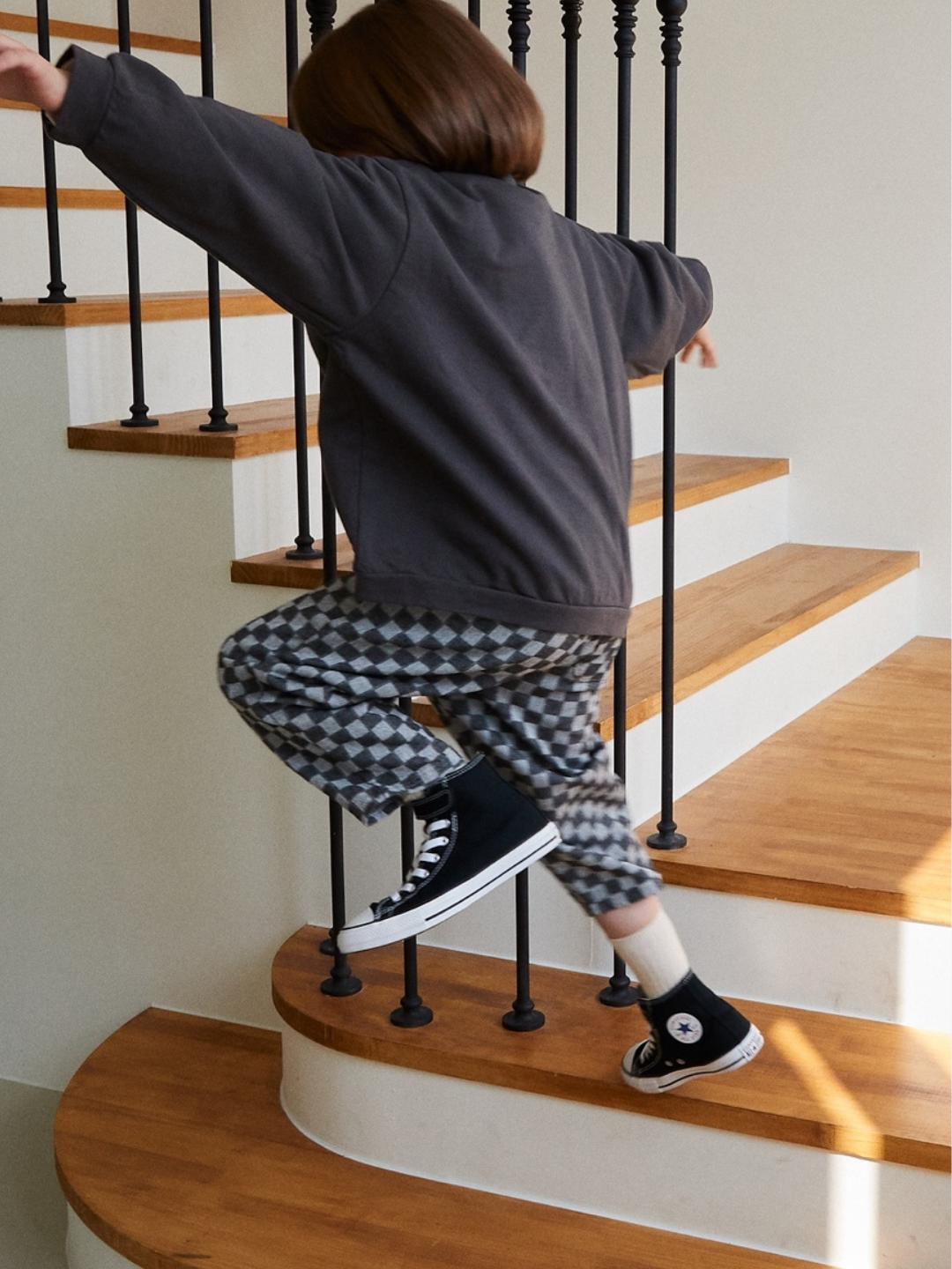 Charcoal | Child wearing chess club pants in charcoal, jumping.