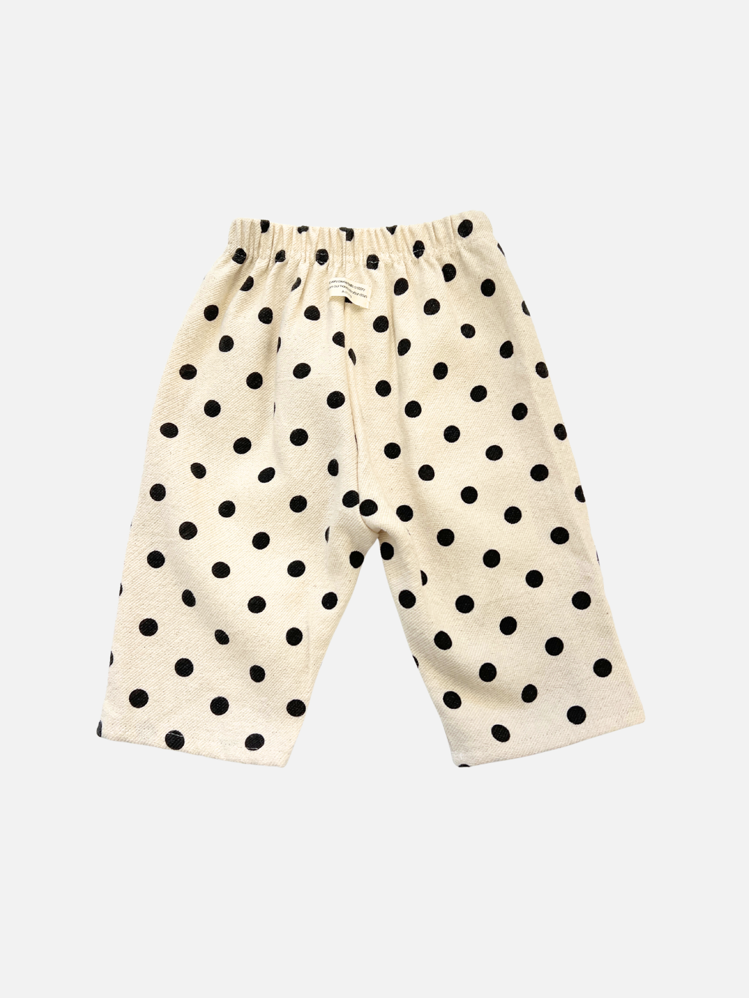 The POLKA DOT PANT features beige fabric with black polka dots, an elastic waistband, and soft double-layer cotton for comfort and a relaxed fit, shown on a white background.