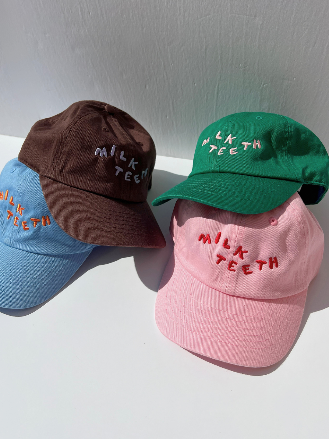 Pink | A stack of Milk Teeth embroidery caps