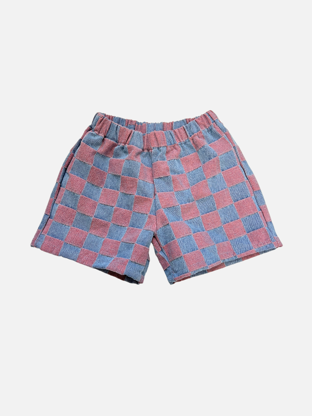 Pink | The TWO TONE DENIM CHECK SHORTS feature an elastic waistband and a pink checkerboard jacquard pattern, inspired by a Korean kids brand, and are presented against a plain white background.
