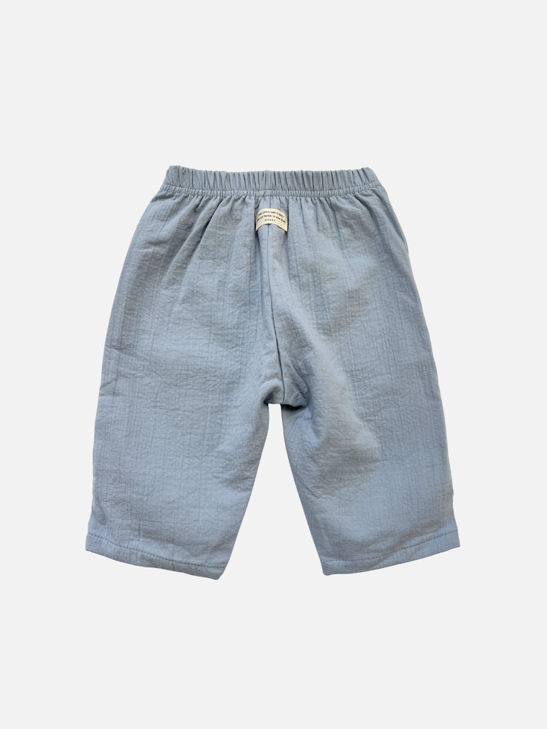 The CLOUD COTTON PANT is a light blue, relaxed fit pant made from breathable woven cotton with an elastic waistband and a small front label, shown on a plain white background.