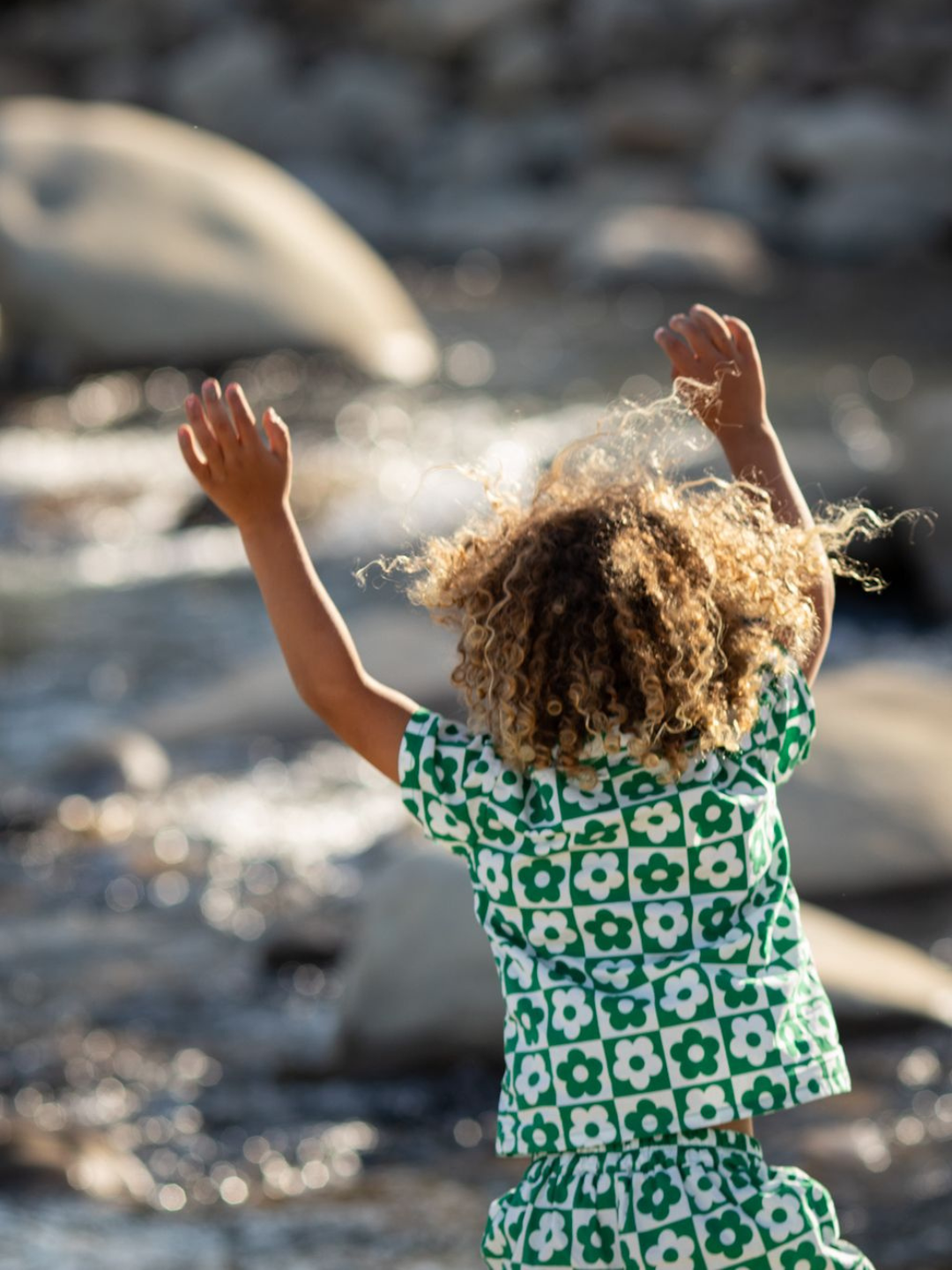 Pine | Child wearing a kids' short set in a checkerboard pattern of green and white flowers, back view