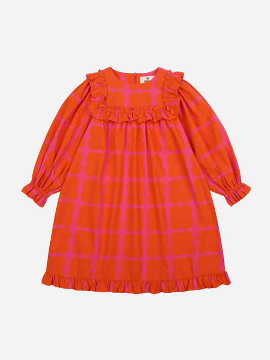 Image of Front of Clover Dress. Bright red and pink dress with a ruffled hem, long sleeves with pleats, and ruffled trim on the collar.