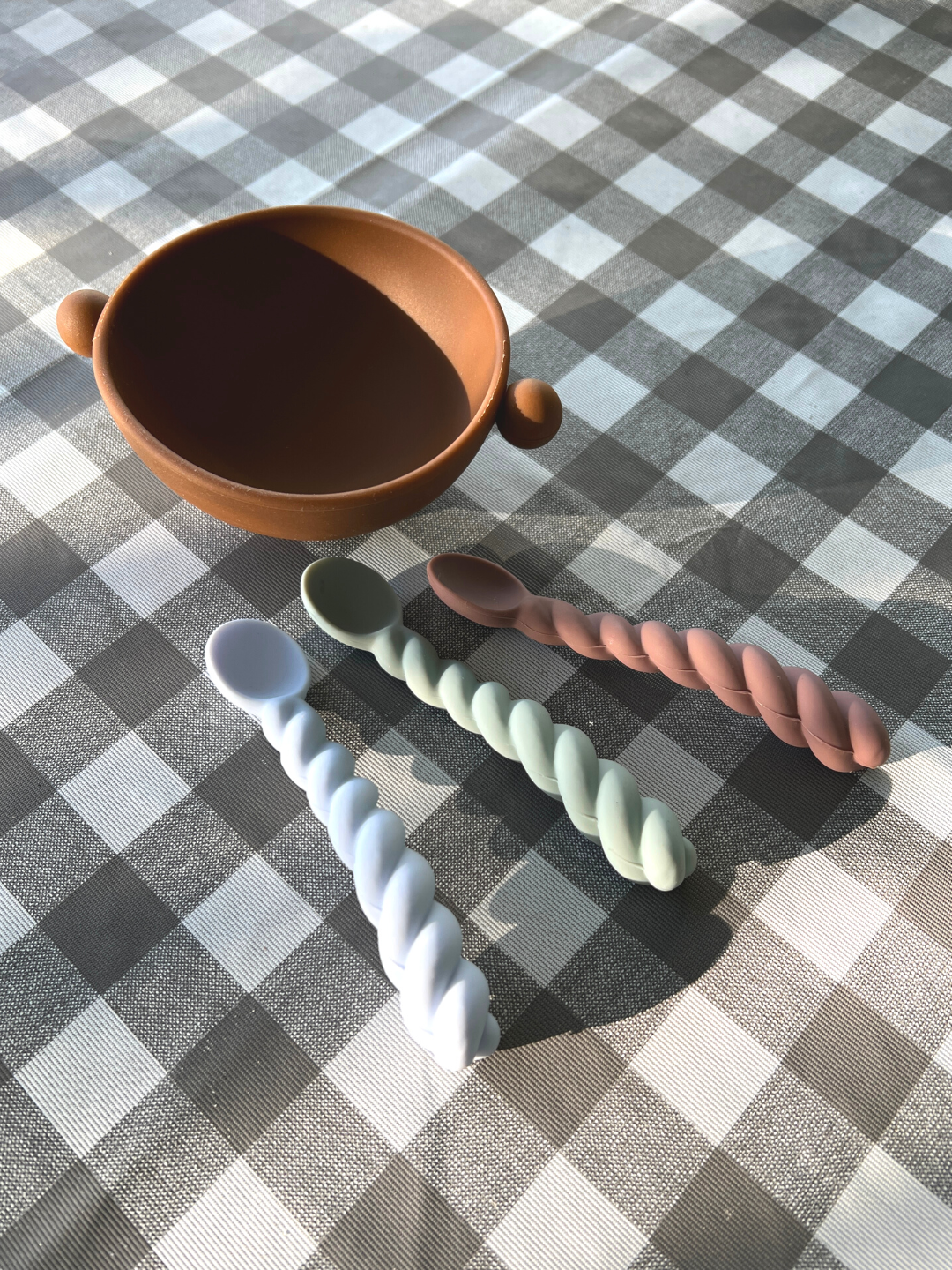 Dusty Blue / Taupe / Pale Mint | Three rubber kids spoons on table cloth next to a bowl