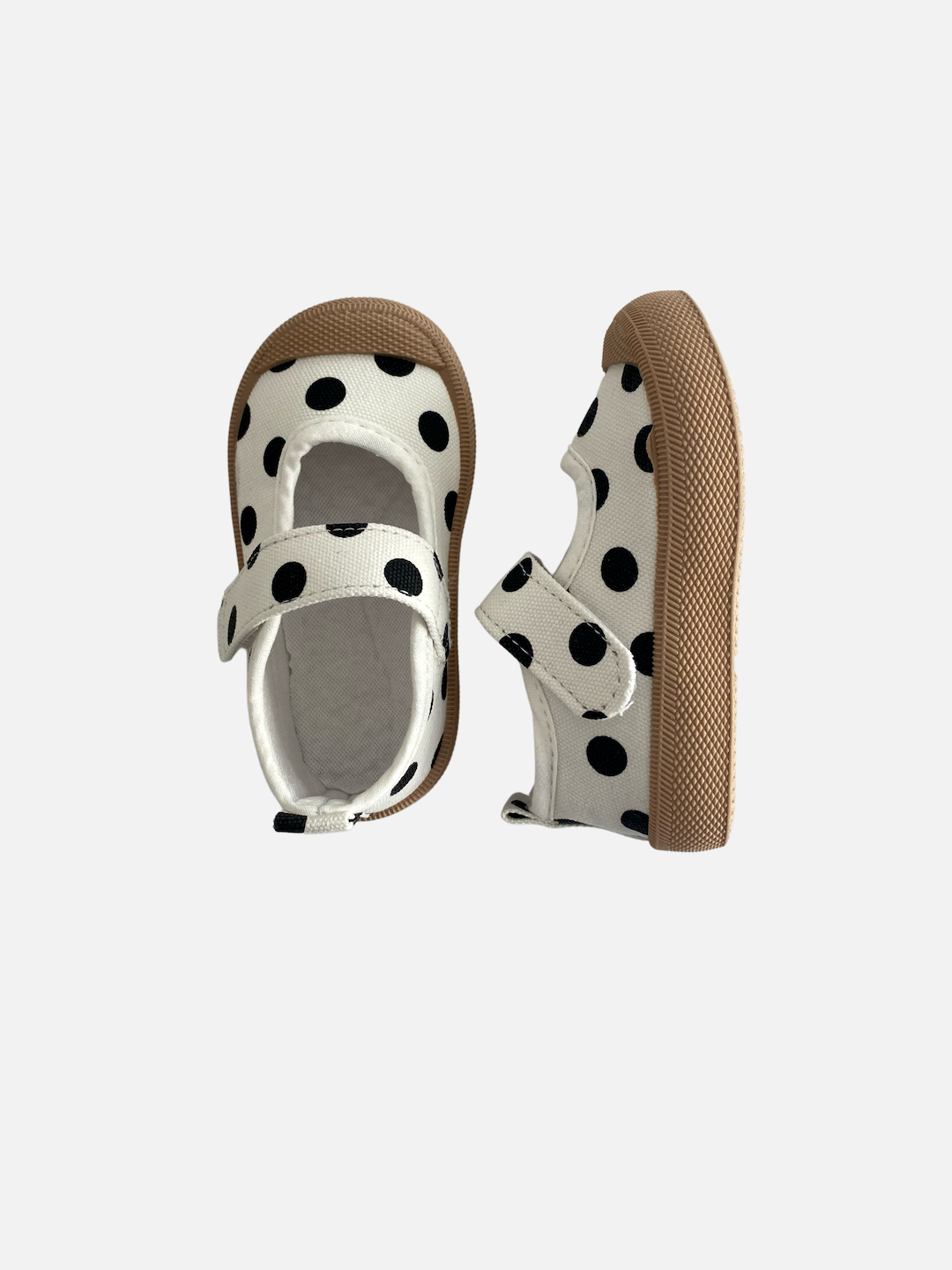 A pair of toddler mary jane sneakers in a pattern of black dots on a white background, top and side view