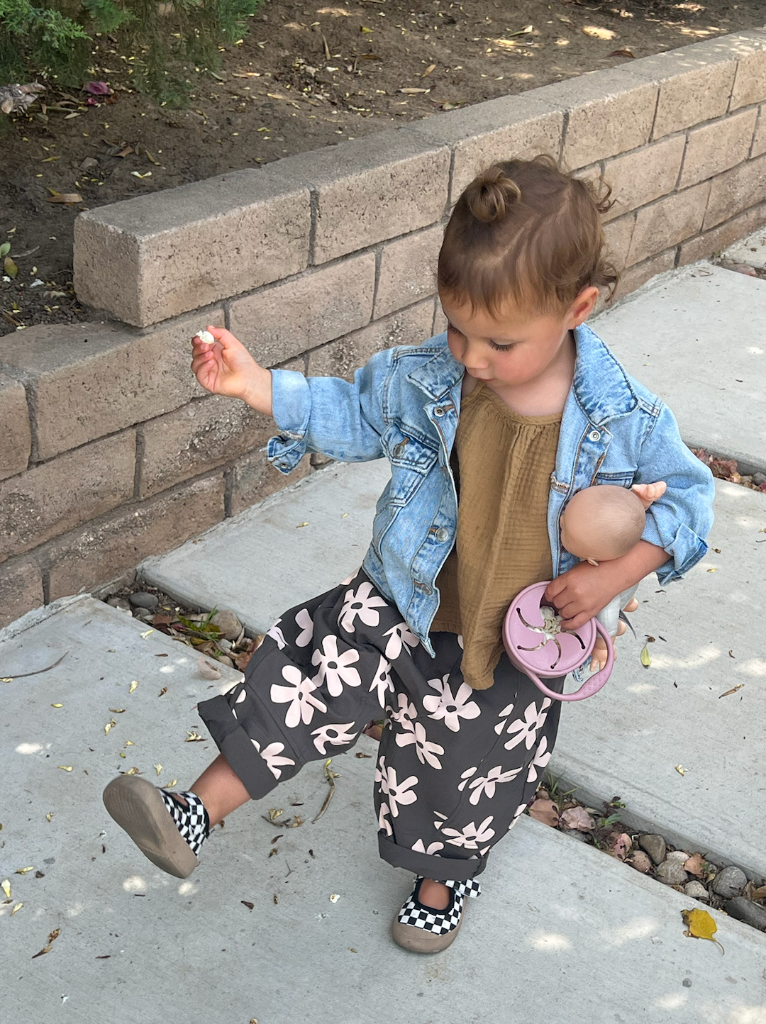 Black | A child walking in a pair of kids' pants, gray with cream flowers