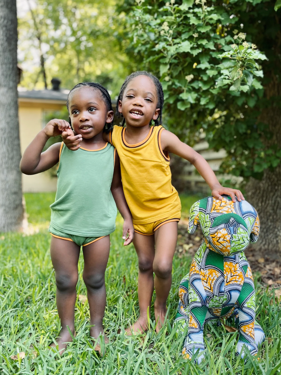 Sunshine | Two children in backyard, one in mint green kids' tank and bloomers, the other in sunshine yellow kids' tank and bloomers