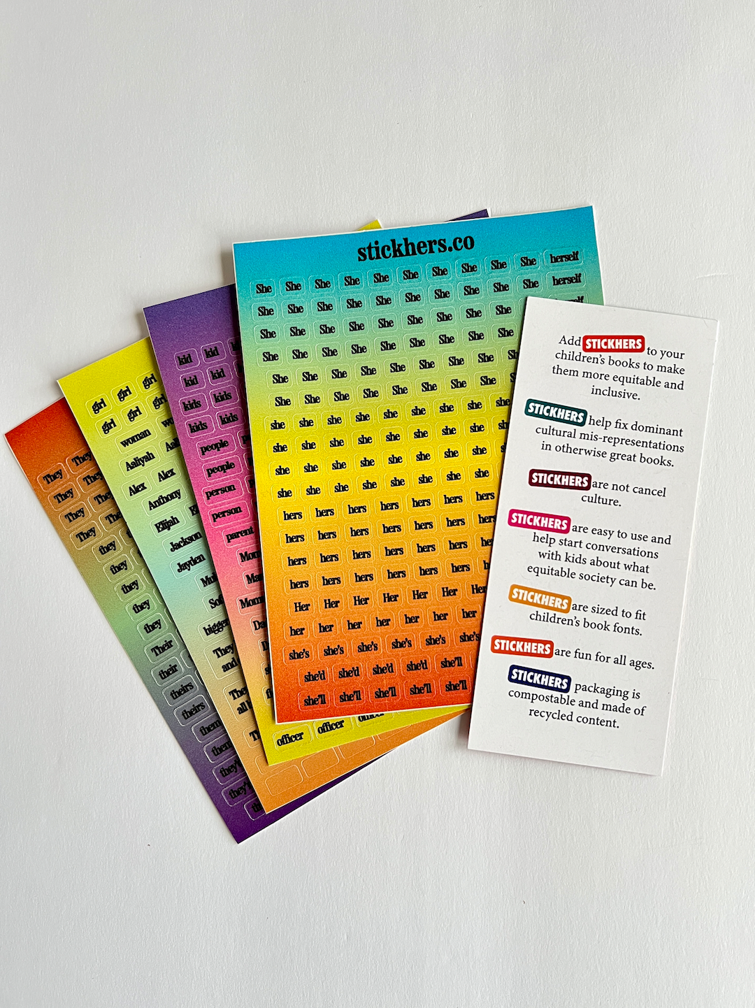 A set of colorful sticker sheets named "StickHERS" prominently featuring the "stickhers.co" label at the top, showcasing various pronouns such as "She," "He," and "They." These gender equity stickers come with a white instruction card containing red and black text that explains their usage and benefits.