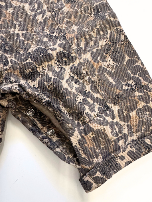 Second image of The BLYTHE LEOPARD DUNGAREE BABY is a pair of unisex, organic cotton leopard-print overalls for toddlers, featuring adjustable straps with metal buckles and buttons—an essential wardrobe staple.