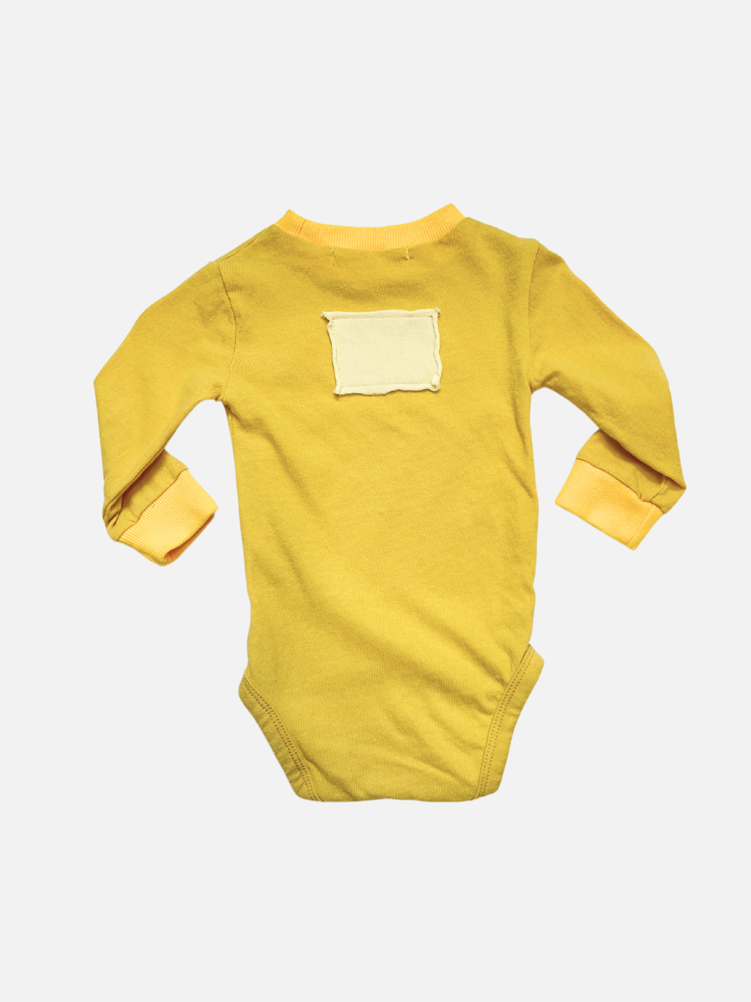 A back view of the baby patch onesie in yellow with ivory rectangular patch on the back
