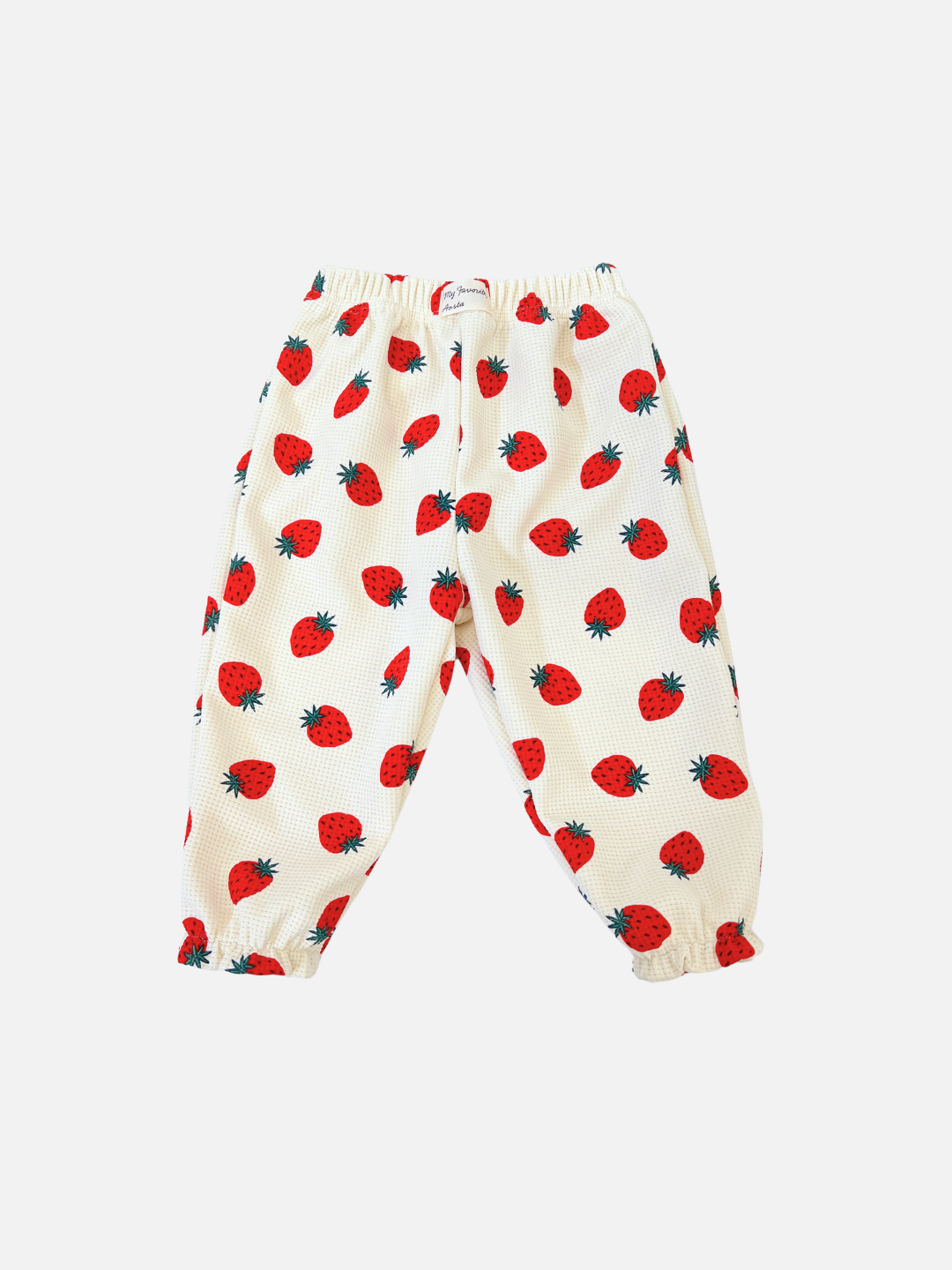 Introducing the STRAWBERRY WAFFLE JOGGER, white pants with an elastic waistband and ankle cuffs featuring a charming strawberry print. From a trendy Korean kids brand, they blend style and comfort for your child.