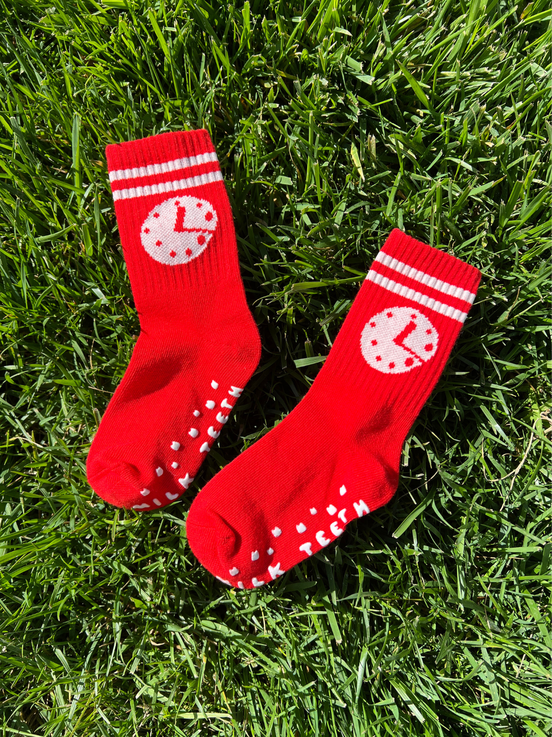 Clock | Red socks with white patterns on grass
