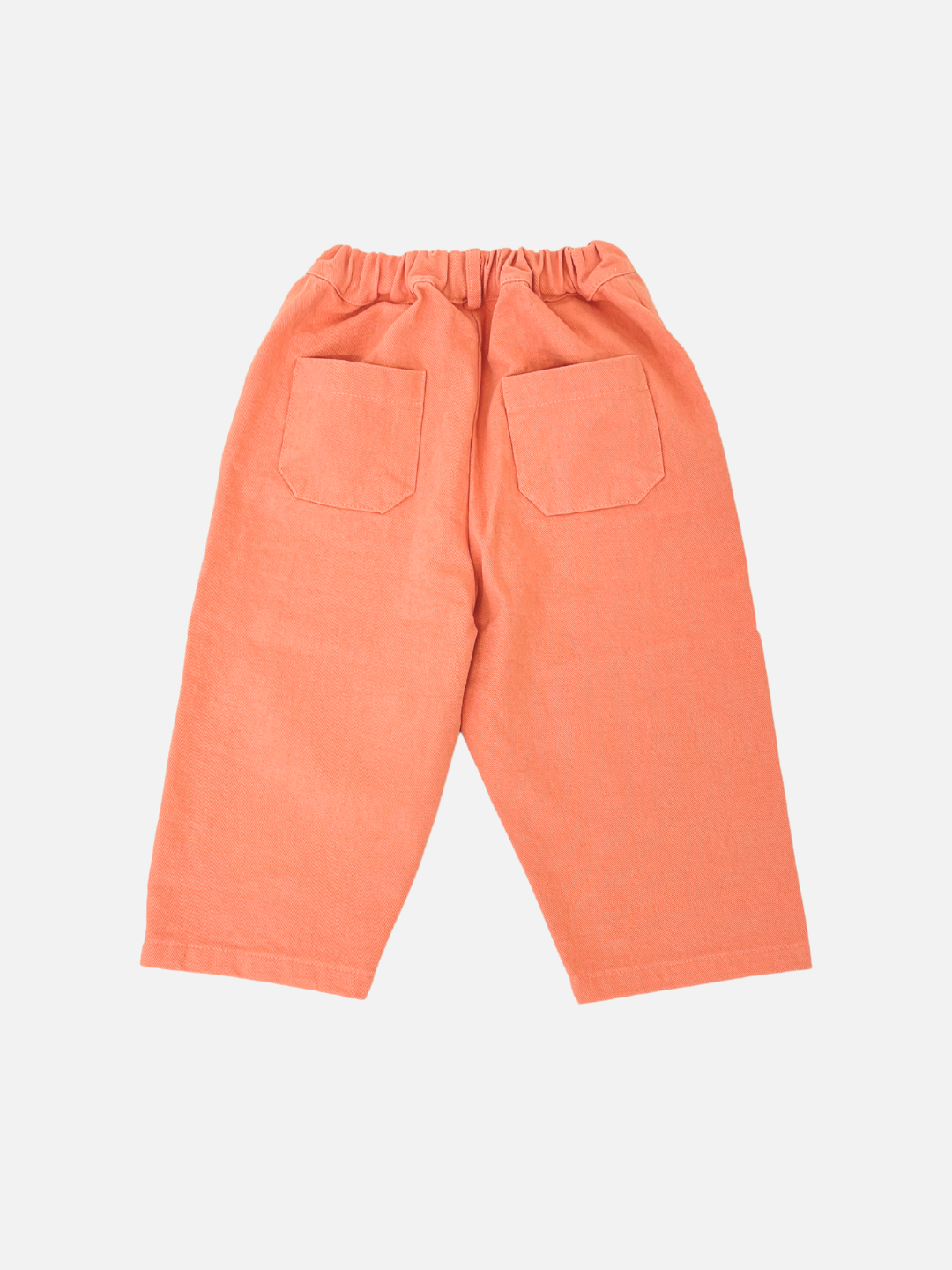 Melon | Tomboy Pants: Orange children's slouchy pants made from cotton twill with an elastic waistband and two back pockets, shown on a white background.