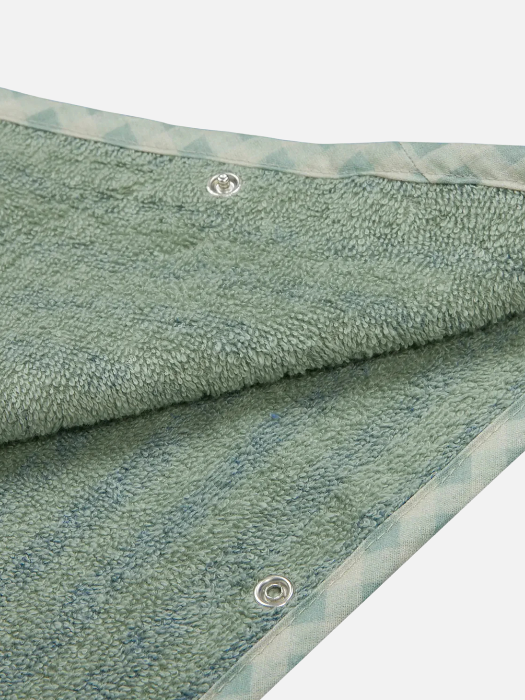 Close-up of a green terry cloth towel with patterned trim and two metal snap buttons, similar to those on the OEKO-TEX certified STRIPED PONCHO for kids.