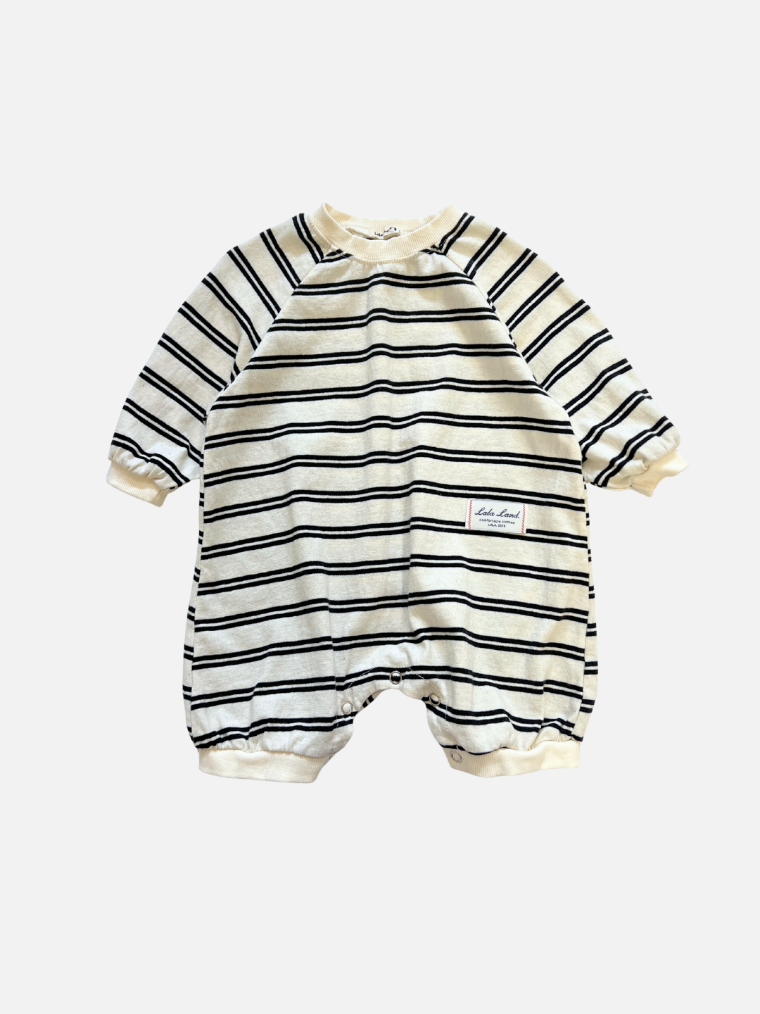 The SLOUCHY STRIPE ROMPER is an off-white cotton jersey shortie with navy stripes, long sleeves, short legs, and a small patch label on the left, from a popular Korean baby brand.
