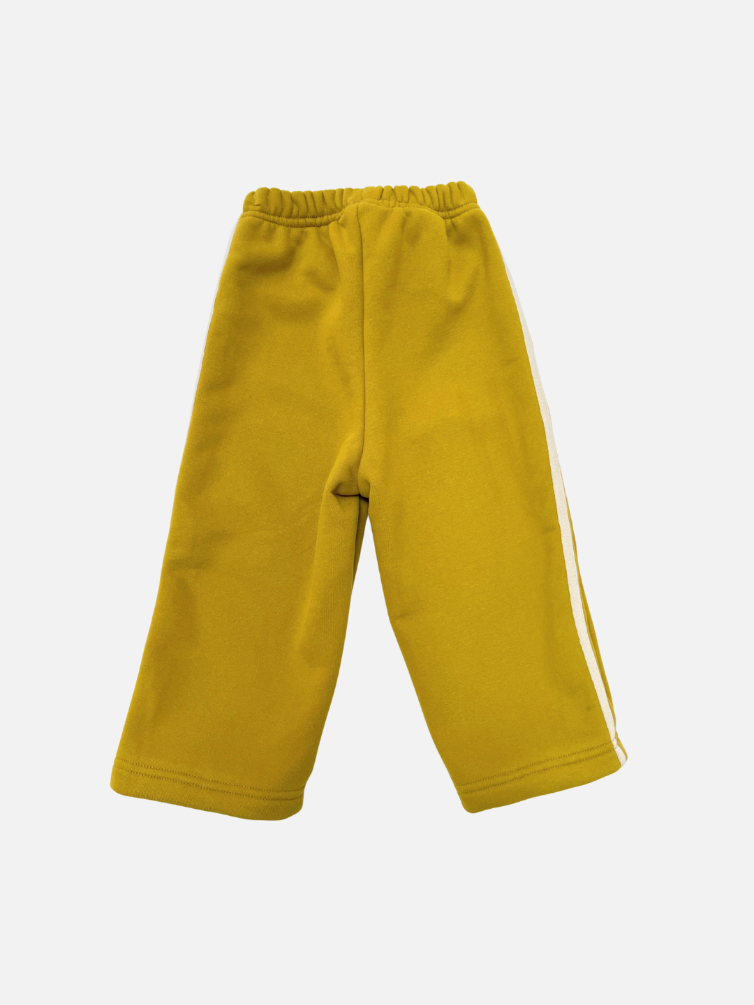 SUNDAY TRACKPANTS: Yellow children's baggy sweatpants with an elastic waistband and a white side stripe, shown on a plain white background.