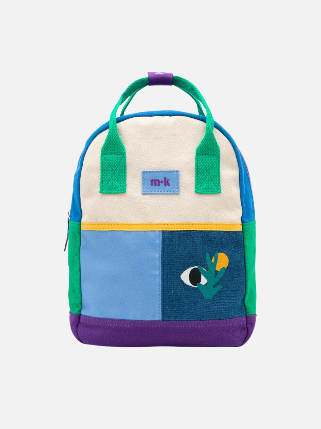 A colorblock backpack with green handles and sides, purple base and two blue patches below a cream top, one with images of an eye, a sun and a plant