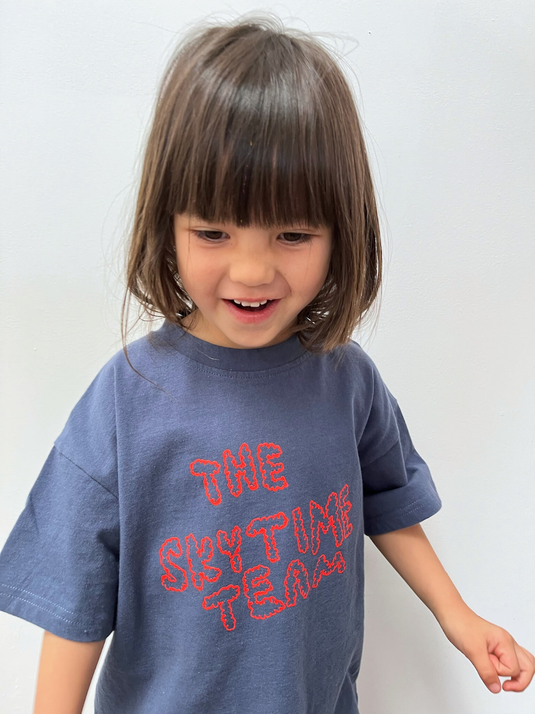 Blue | Child wearing a blue t-shirt with red text on a white background