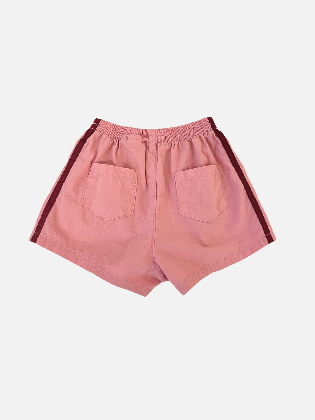 Back view of the kids' dusty pink shorts with burgundy stripes on the sides and two back pockets. 