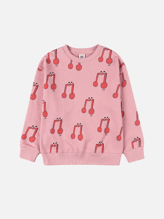 Image of The MELODY PATTERN SWEATSHIRT is a pink children's sweatshirt with a lively red musical note pattern featuring smiling faces on white, delivering cheerful style at an affordable price.