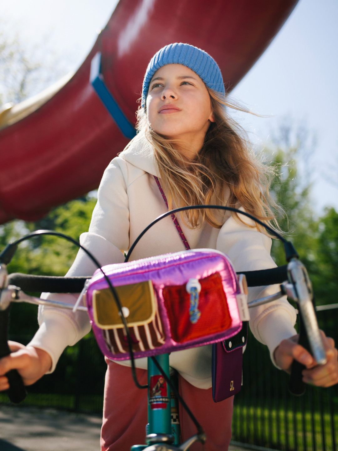 Glossy Pink | A child is riding a bike with a Glossy Pink bike bag in the front. 