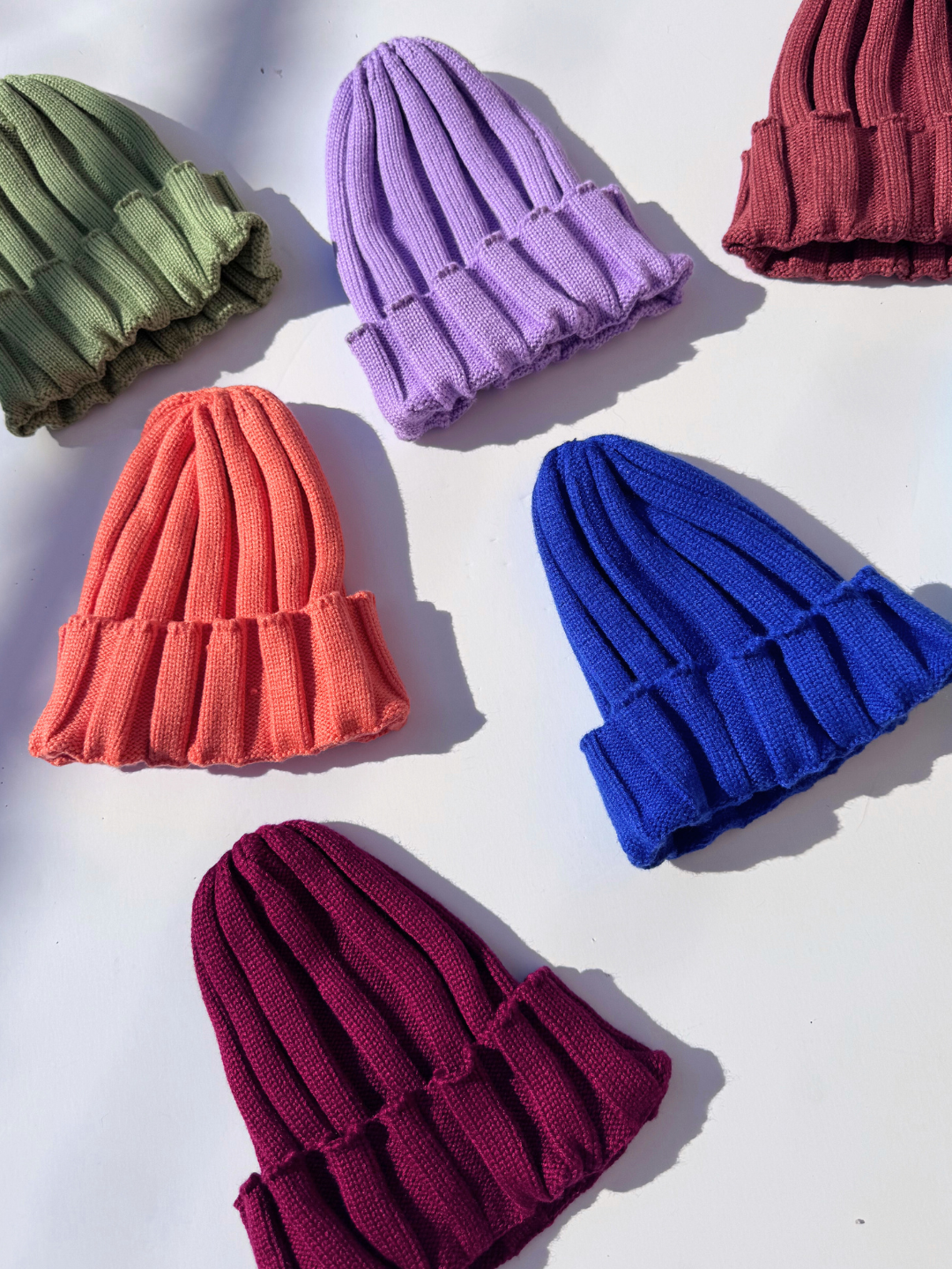 Maroon | Colorful knit hats arranged on a white background