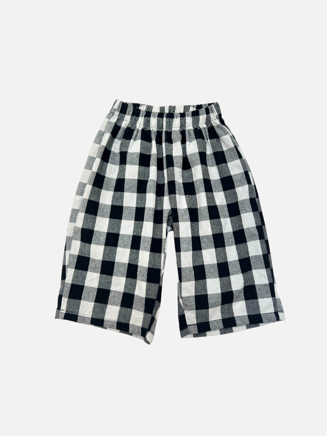 Black + White | GINGHAM BABY PANTS: Toddler cotton pants with a black and white checkered pattern and an elastic waistband, laid flat on a white background.