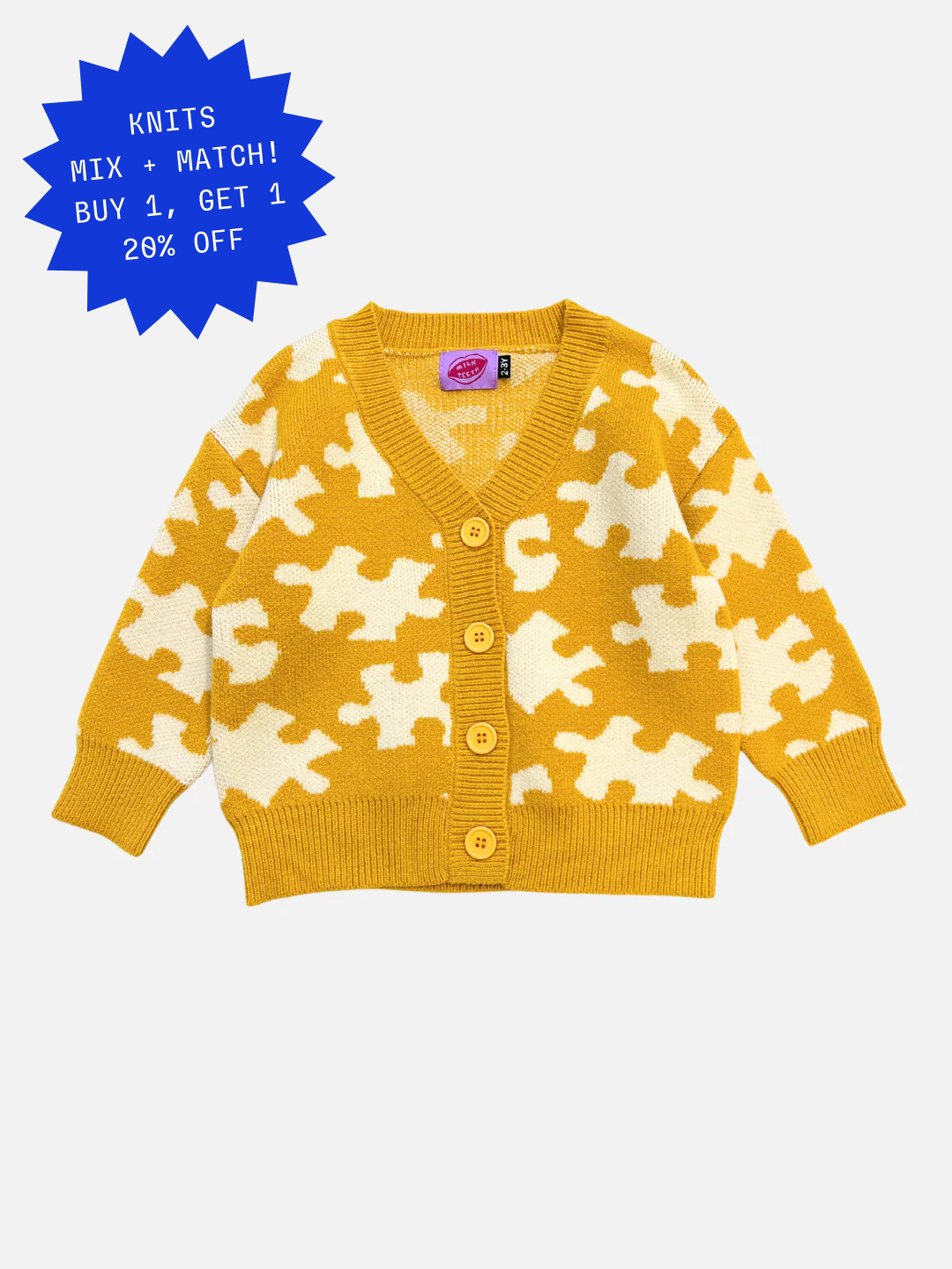 The PUZZLE CARDIGAN is a yellow knitted children's cardigan featuring a puzzle piece pattern, long sleeves, and four yellow buttons down the front.
