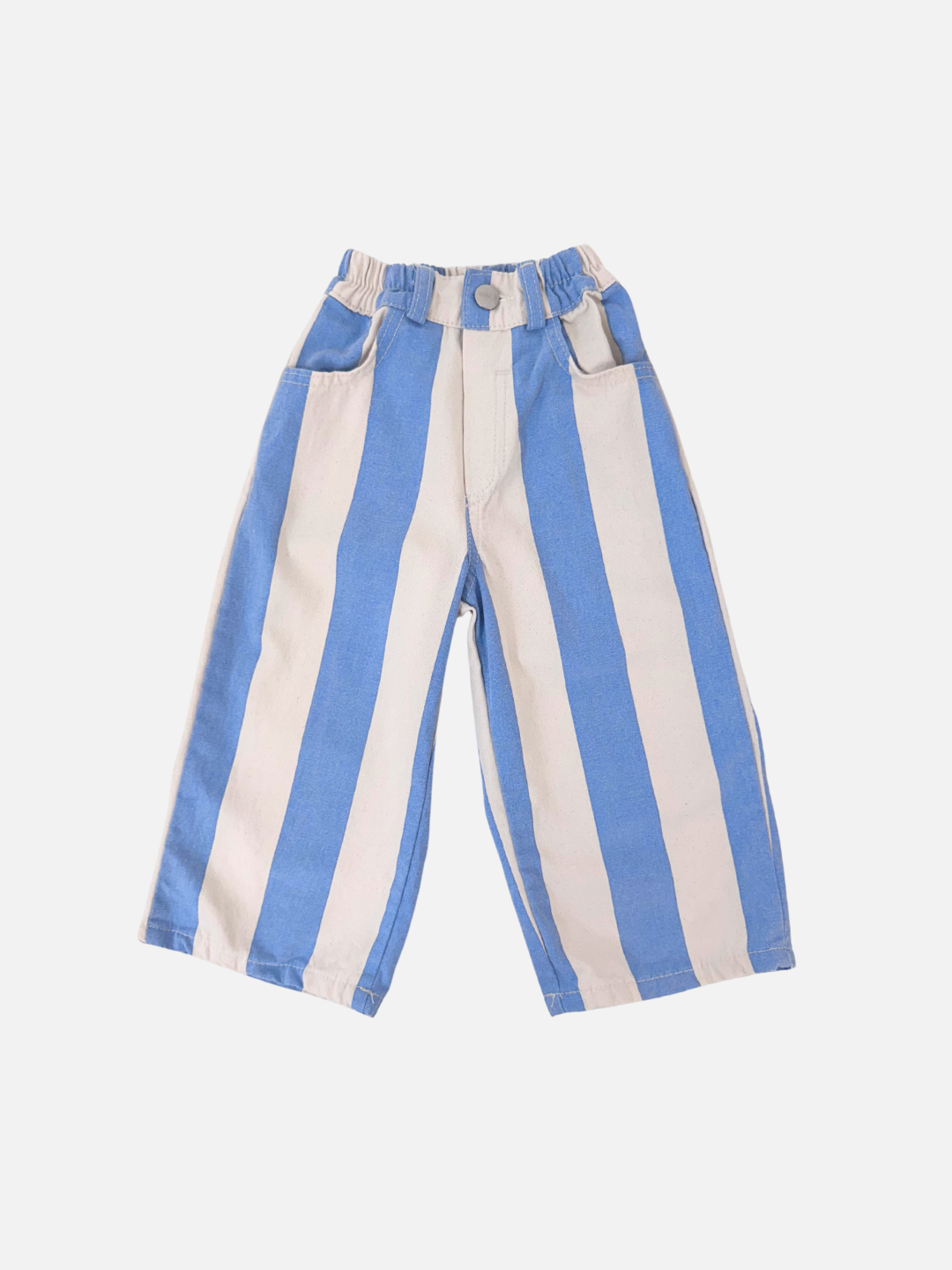 The CABANA STRIPE PANTS are blue and white vertically striped children's pants from a Korean brand. They feature an elastic waistband, high waist, front button, and pockets. Made from durable cotton canvas, they lay flat on a plain white background.